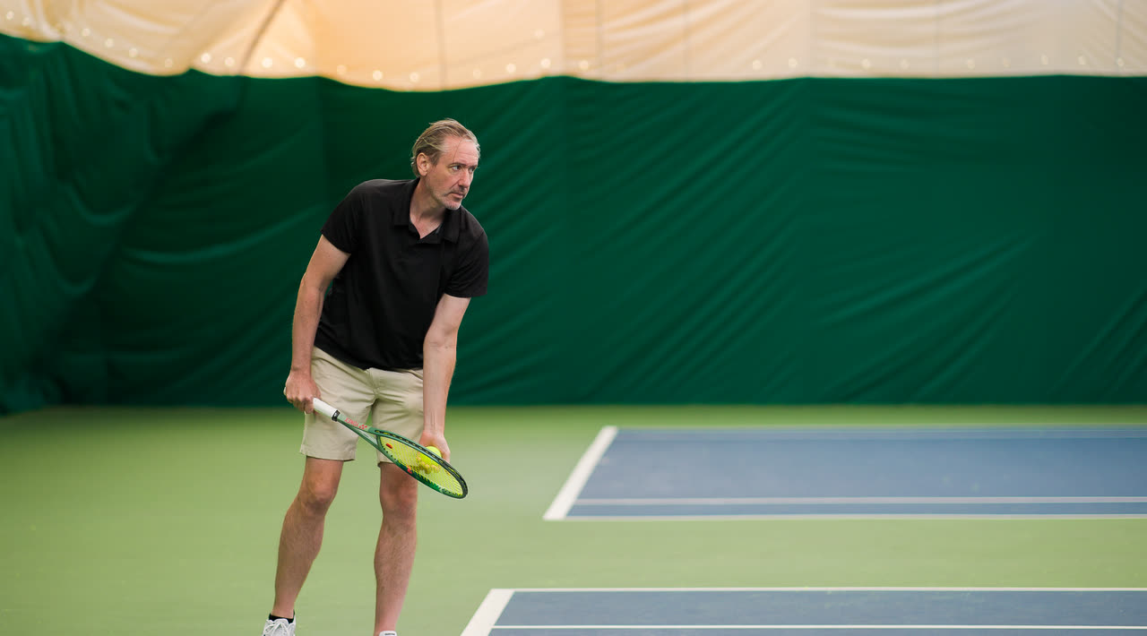 A player waiting at the baseline on an indoor court at Match Point KC